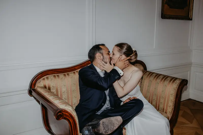 Brautpaar küsst sich auf der Couch im Schloss Miller von Aichholz